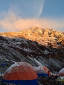 Carpas del campo base con el Aconcagua iluminado al atardecer